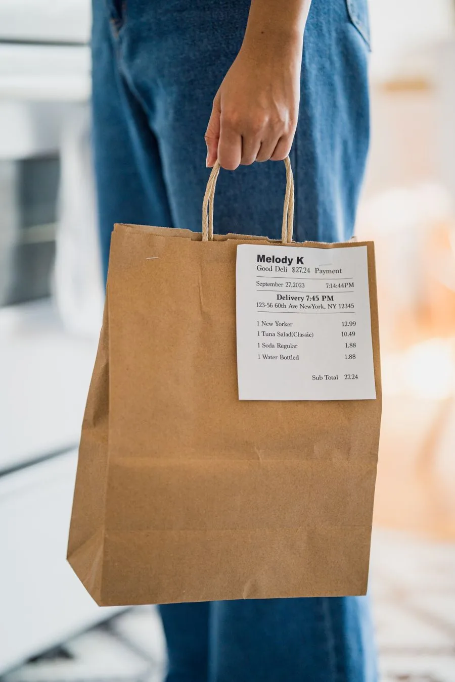 A takeout order in a paper bag with the receipt attached