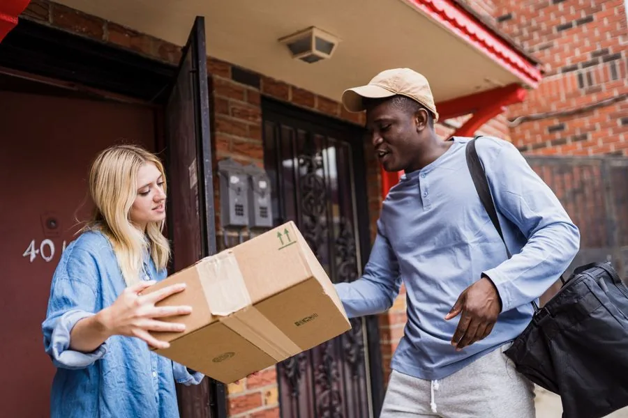 A courier handing a package to a customer at the front door